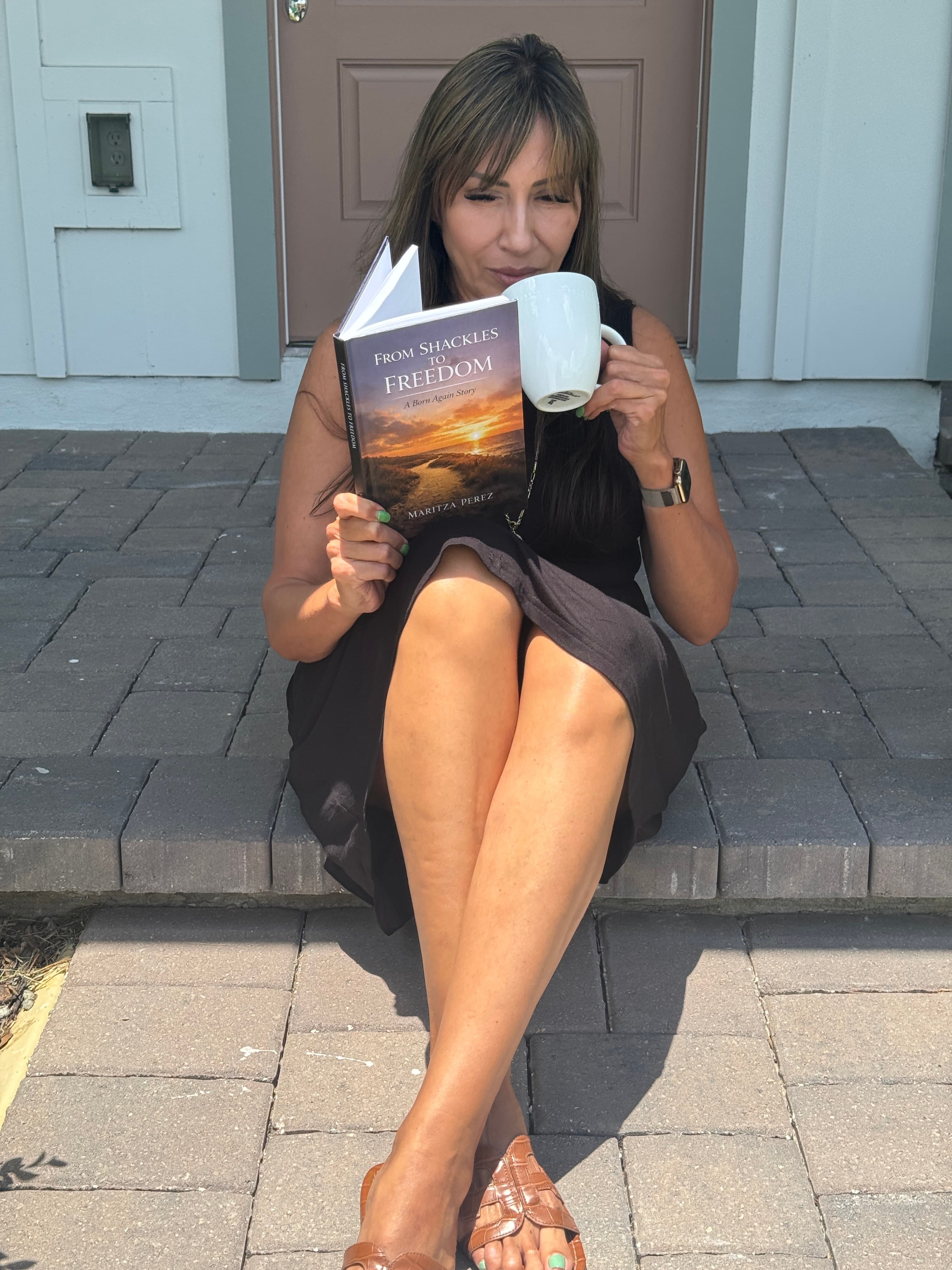 Maritza Perez holding a copy of From Shackles to Freedom